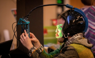 Person wearing a VR helmet connected to a controller